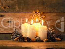 Fourth Advent candle burning on a rustic wooden table