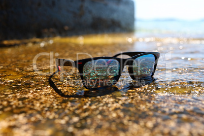 Sunglasses on the background of the sea on a sunny day