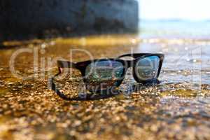 Sunglasses on the background of the sea on a sunny day