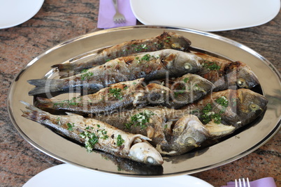 Grilled sea fish stands on the table