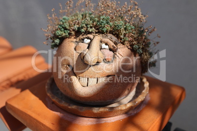 A flower pot in the form of a funny face