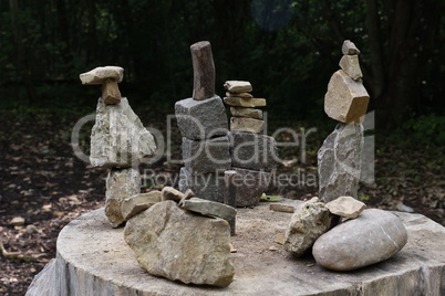 Balanced pyramids of natural stones on an old tree stump
