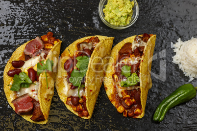 gebackene Tacos auf schwarzem Schiefer