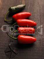 Five freshly harvested homegrown hot peppers on a rustic kitchen