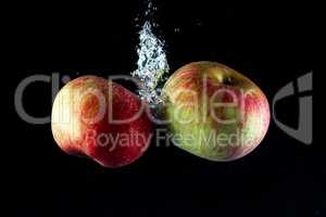 Two apples in water on a black background