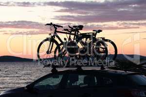 Bicycles by car on a sunset background