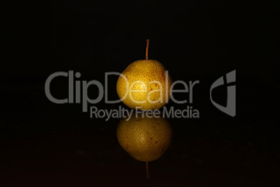 A yellow pear on a black background