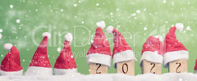 Many hats of Santa in a row with snow