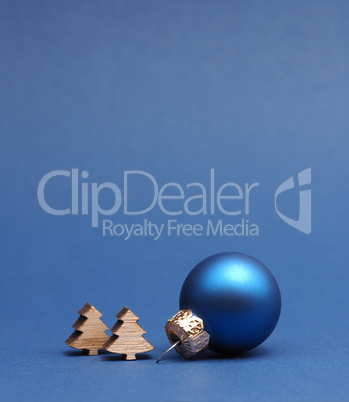 Blue Christmas tree ball with small wooden tree shapes on a blue