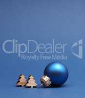 Blue Christmas tree ball with small wooden tree shapes on a blue