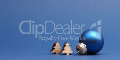 Blue Christmas tree ball with small wooden tree shapes on a blue