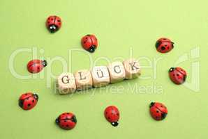 Wooden blocks with German word luck on a green background