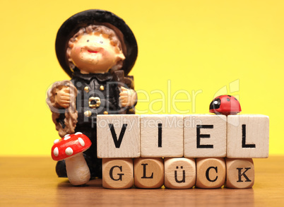 Wooden blocks with German words good luck on yellow background