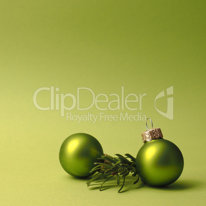 Green vintage Christmas baubles on a green background