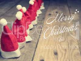 Many hats of Santa on a rustic wooden table, Merry Christmas