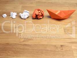 Teamwork business concept with crumpled paper and a paper boat o