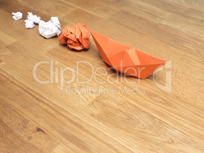 Teamwork business concept with crumpled paper and a paper boat o