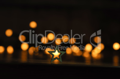 Small wooden star shape with blurred lights