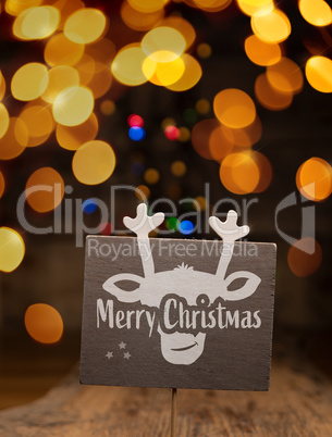 A wooden sign with a reindeer face and the words Merry Christmas