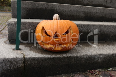 Halloween pumpkin on the steps at the entrance to the house