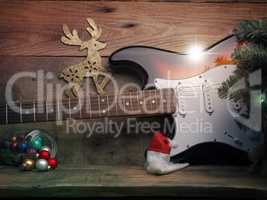 Old used vintage guitar with Christmas lights on a wooden plank