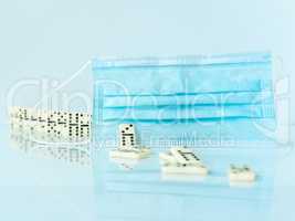 Surgical mask stopping domino effect on white background.