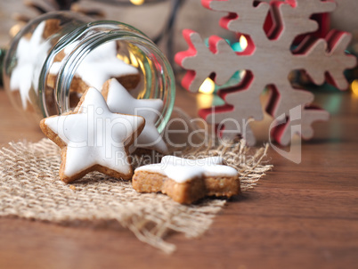 Cinnamon stars in a jar with Christmas decoration on a wooden ta