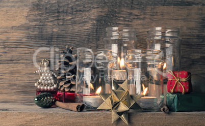 Candle burning on a rustic wooden table with Christmas decoratio