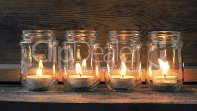 Candle burning on a rustic wooden table