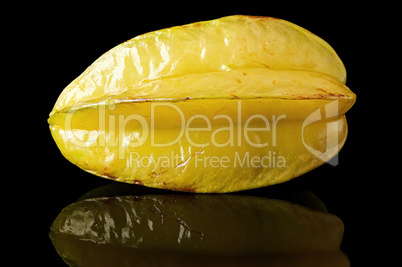 Ripe yellow carom with reflection on black