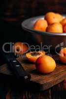 Mellow apricots with knife over cutting board