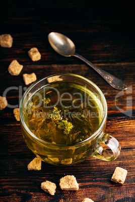 Cup of green tea with brown tea sugar