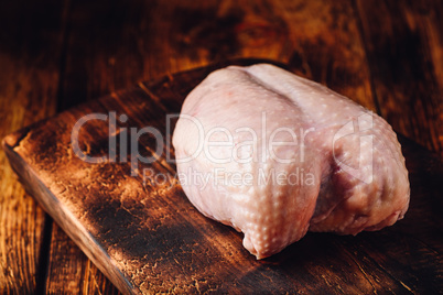 Raw chicken breast on chopping board