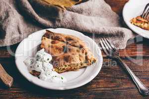 Slice of cabbage pie with sour cream sauce