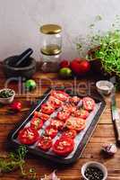 Halved Tomatoes with Thyme and Garlic on Baking Sheet
