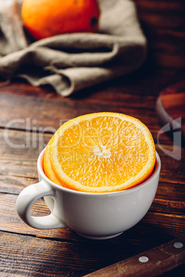 Sliced orange in a white cup