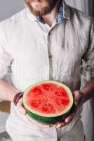 Bearded man with half of watermelon