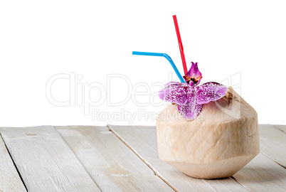 Young coconut with orchid flower on wooden table