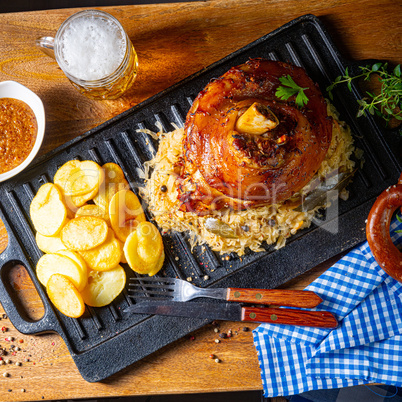 rustic pork knuckle with sauerkraut, sweet mustard and fried pot