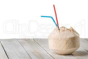 Young coconut on wooden table isolated on white