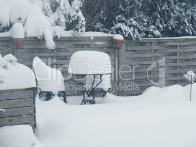 Heavy snowfall. Garden furniture is covered with a lot of snow
