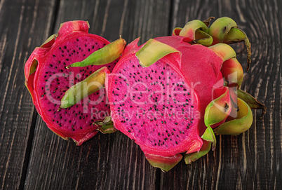 Two halves of dragon fruit on planks