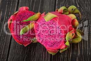 Two halves of dragon fruit on planks