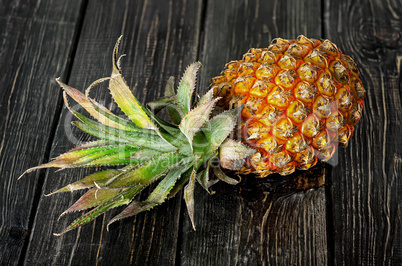 Ripe pineapple lies on a wooden table