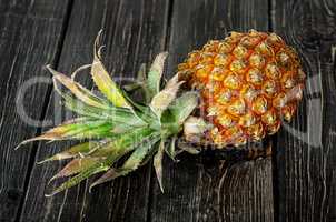 Ripe pineapple lies on a wooden table