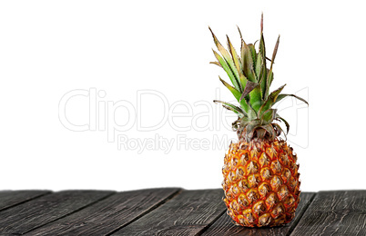 Pineapple stands on wooden boards isolated on white