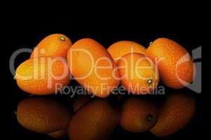 Heap of ripe kumquats on black background