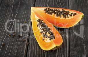 Two pieces of ripe papaya on a wooden table