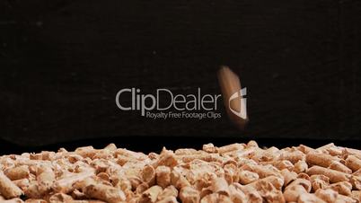 Wood pellets fall on a pile in slow motion