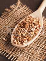 Organic buckwheat on a wooden cooking spoon